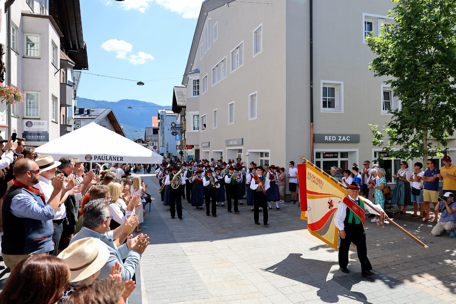 Der Musikverein Lana marschiert mit der Vereinsfahne durch die Telfer Fußgängerzone